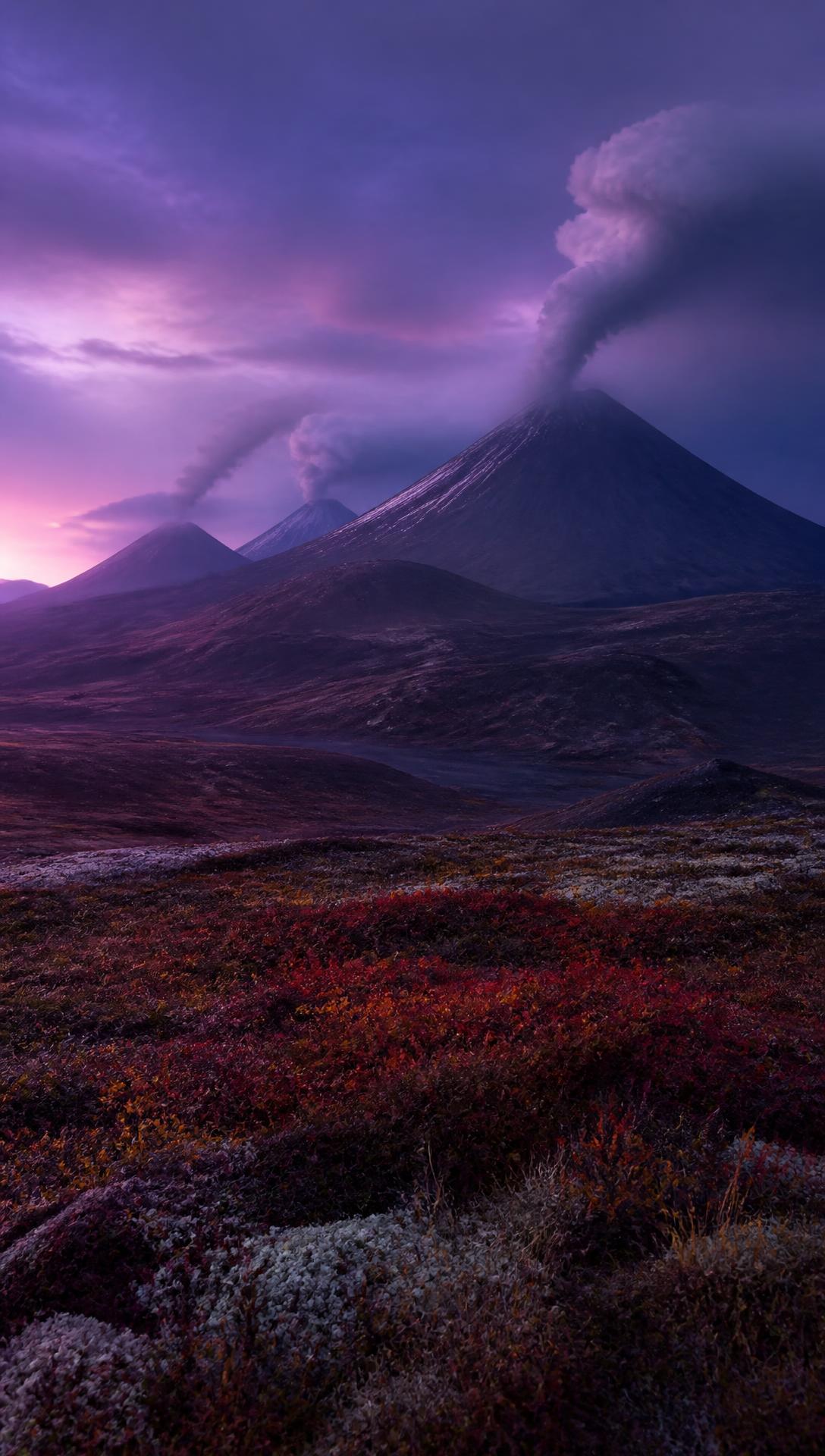 Kamchatka volcanoes steaming under a purple twilight sky